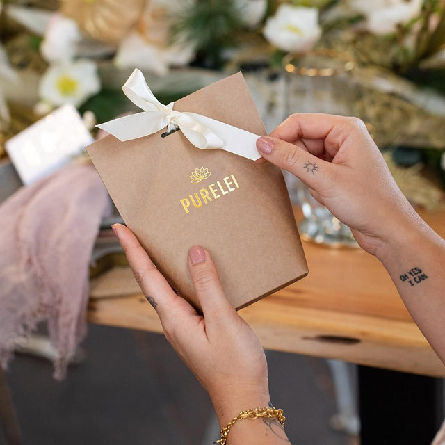 PURELEI Geschenkverpackung Basic aus braunem Kraftpapier mit goldener Prägung und cremeweißem Band, elegant und nachhaltig.