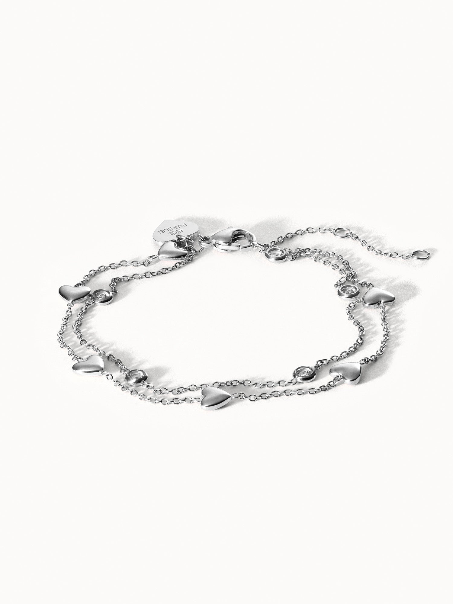 Silbernes Armband mit Herzanhängern von PURELEI, elegant und verspielt.