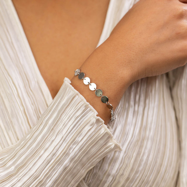 Kalani Armband aus nickelfreiem, silbernem Edelstahl mit feinen Plättchen, elegant am Handgelenk getragen.