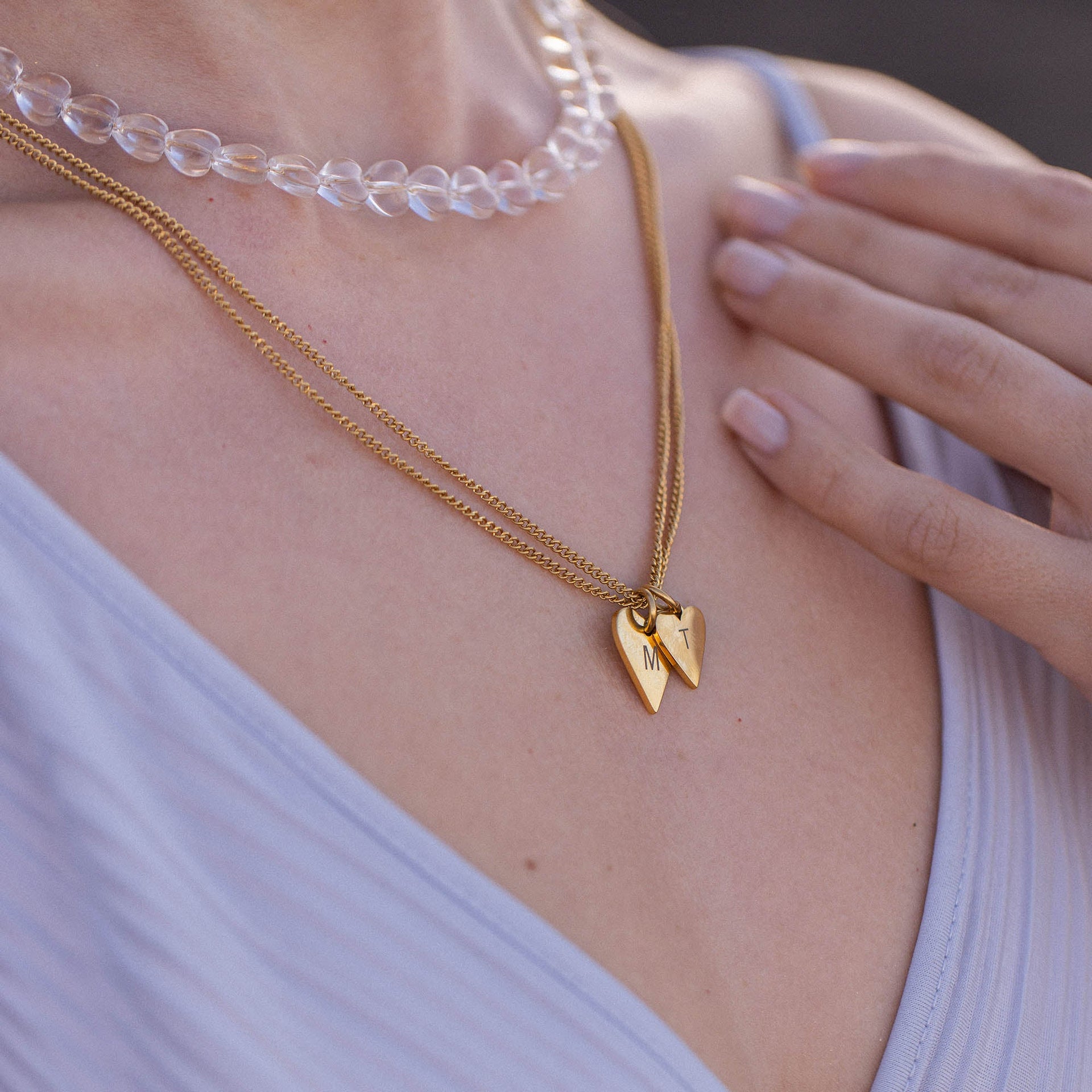 Zwei Herzen aus Roségold an zarten Ketten, getragen mit Aloha-Vibes von PURELEI.