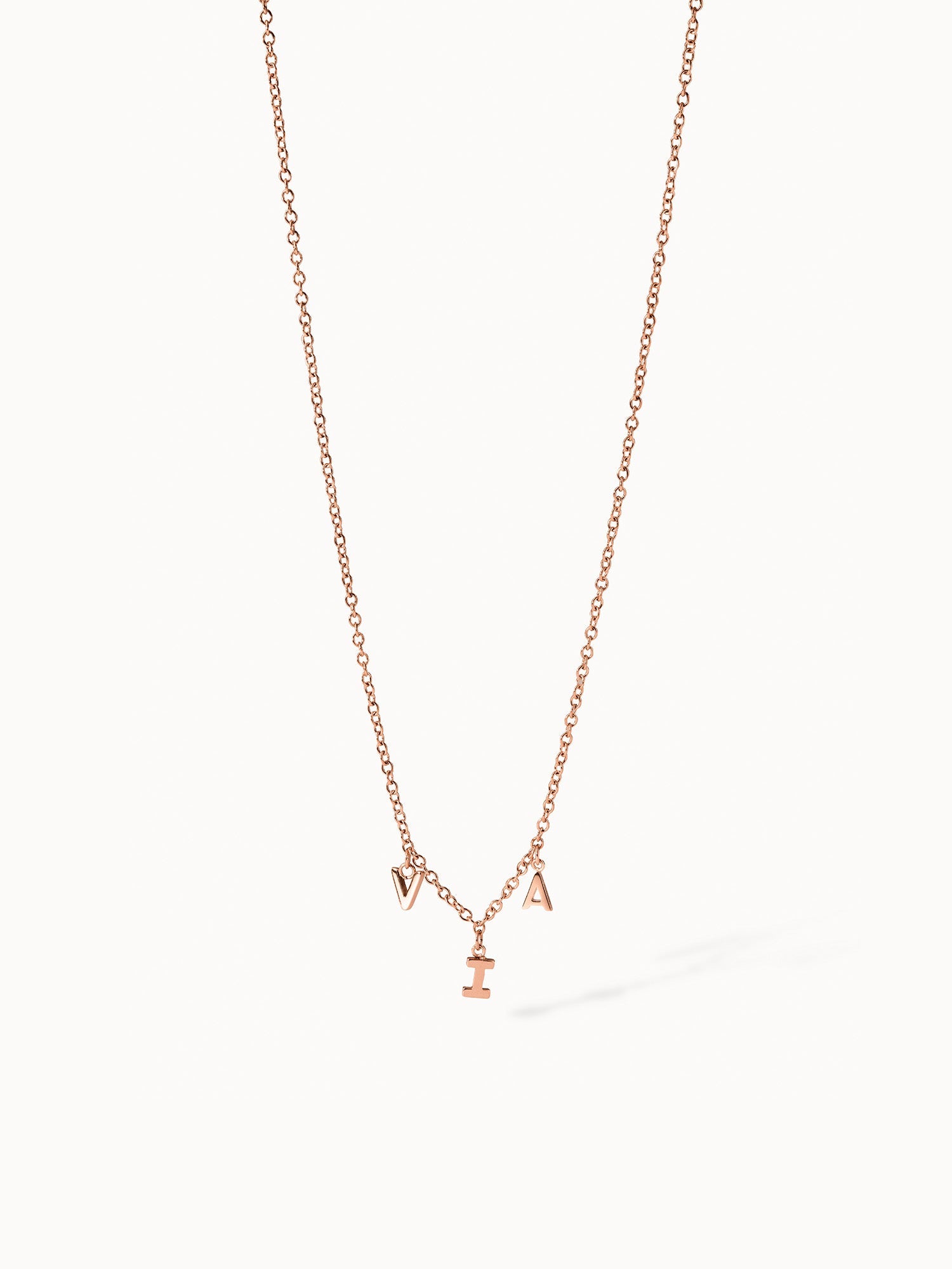 Roségoldene Kette mit Buchstaben-Anhängern von PURELEI, elegant und verspielt.