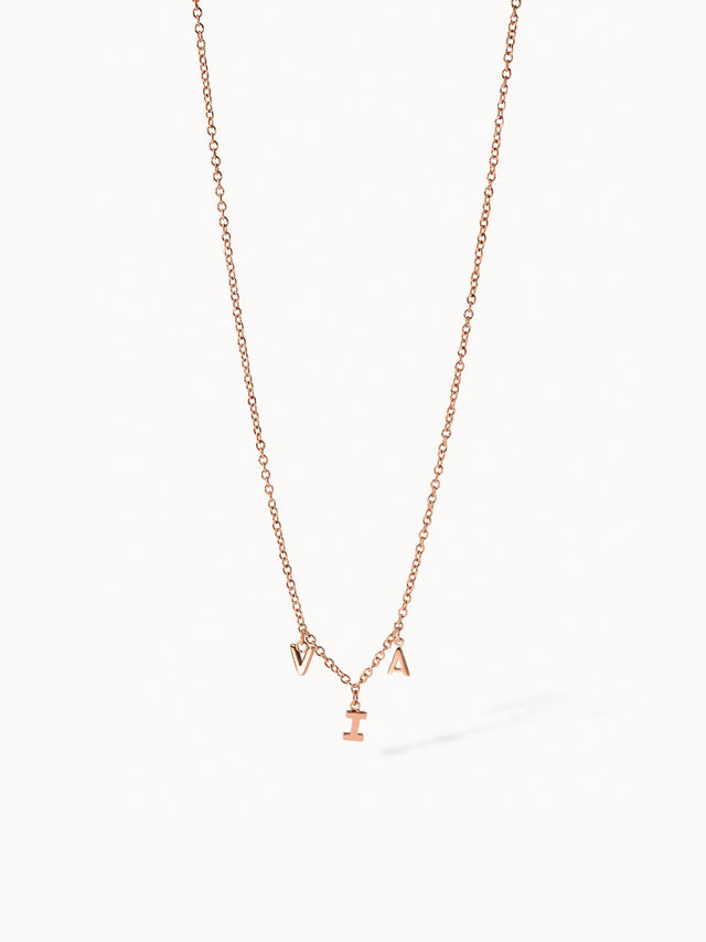 Roségoldene Kette mit Buchstaben-Anhängern von PURELEI, elegant und verspielt.