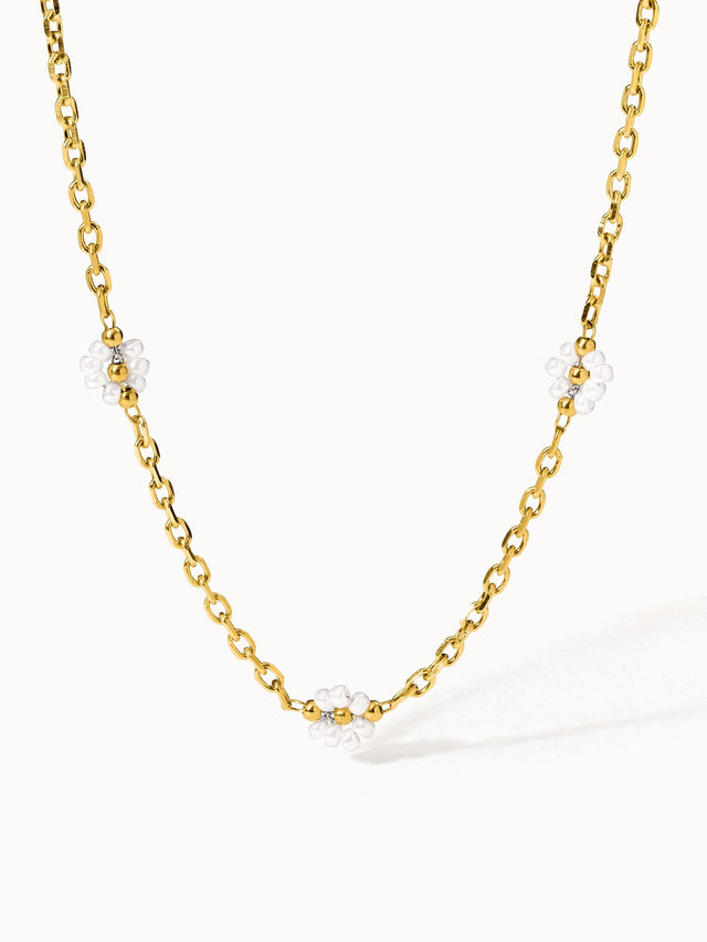 Goldene Kette mit weißen Blüten-Details von PURELEI, elegant und verspielt.
