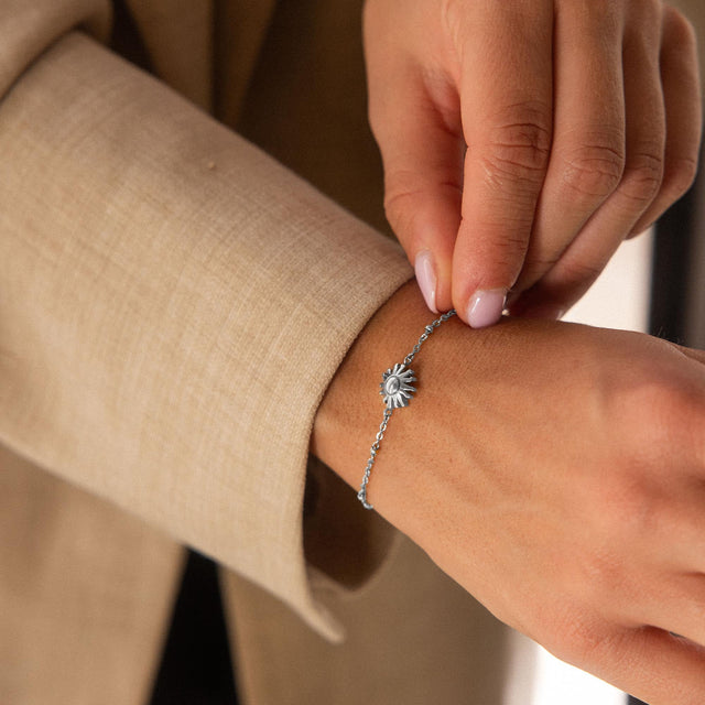 Silbernes Armband mit Sonnenmotiv, elegant am Handgelenk getragen, von PURELEI.