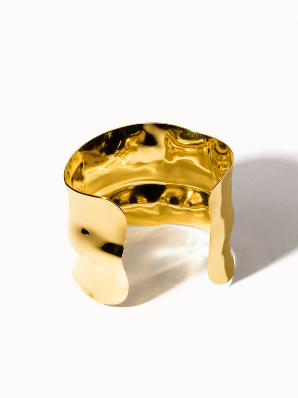 Goldenes, gewelltes Armband von PURELEI mit glänzender Oberfläche, elegant und modern.