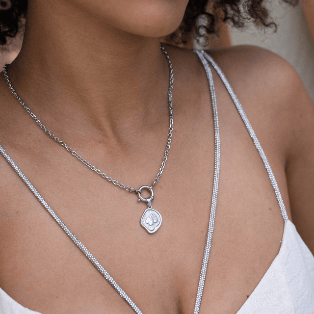 Silberne Kette mit Anhänger, elegant und feminin, getragen auf zartem Dekolleté – PURELEI.