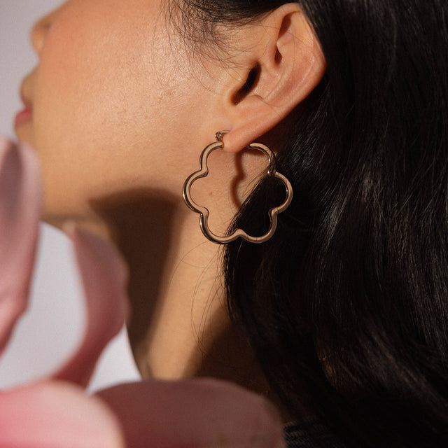 PURELEI Bloom Ohrringe in goldener Blütenform, elegant getragen, femininer Island-Spirit mit warmem Glanz