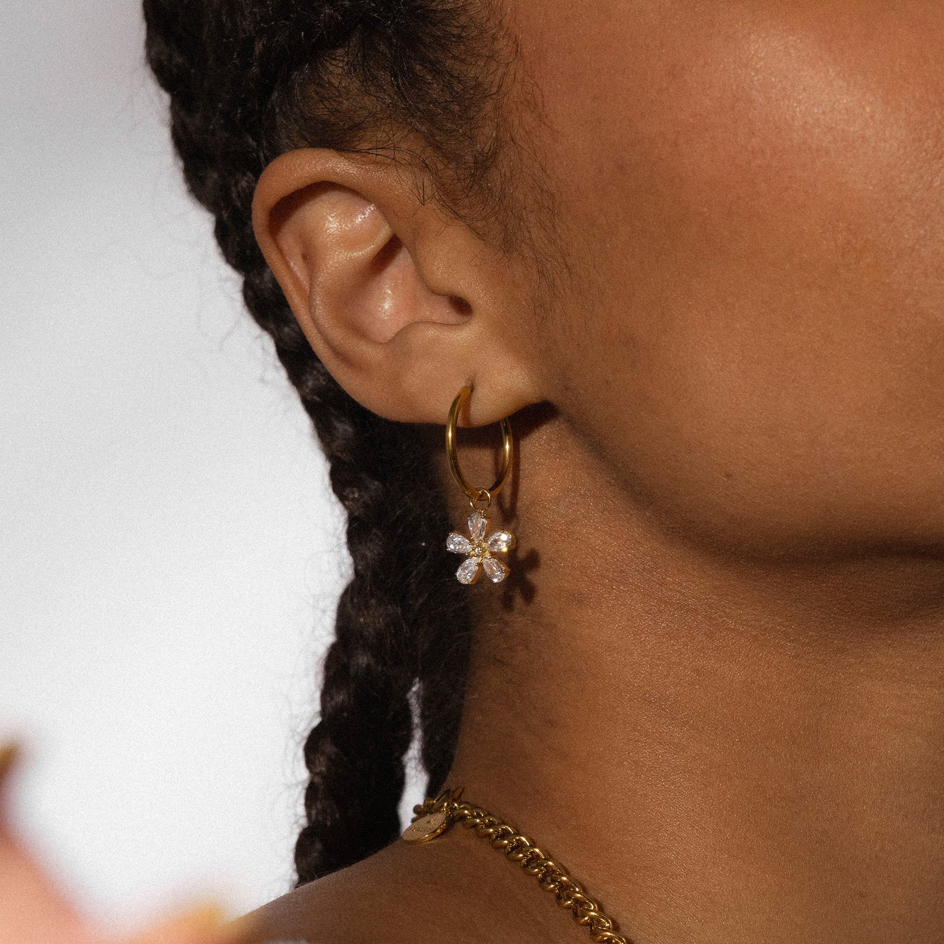 Goldene Creolen mit blütenförmigem Anhänger, PURELEI, elegant und feminin.