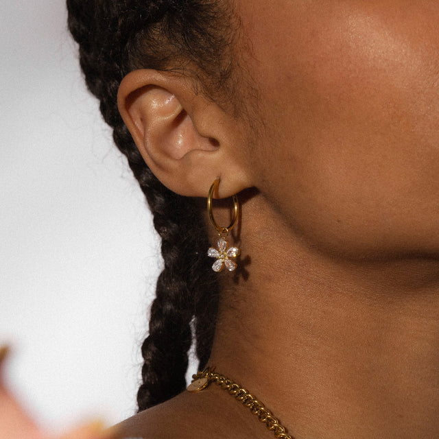 Goldene Creolen mit blütenförmigem Anhänger, PURELEI, elegant und feminin.