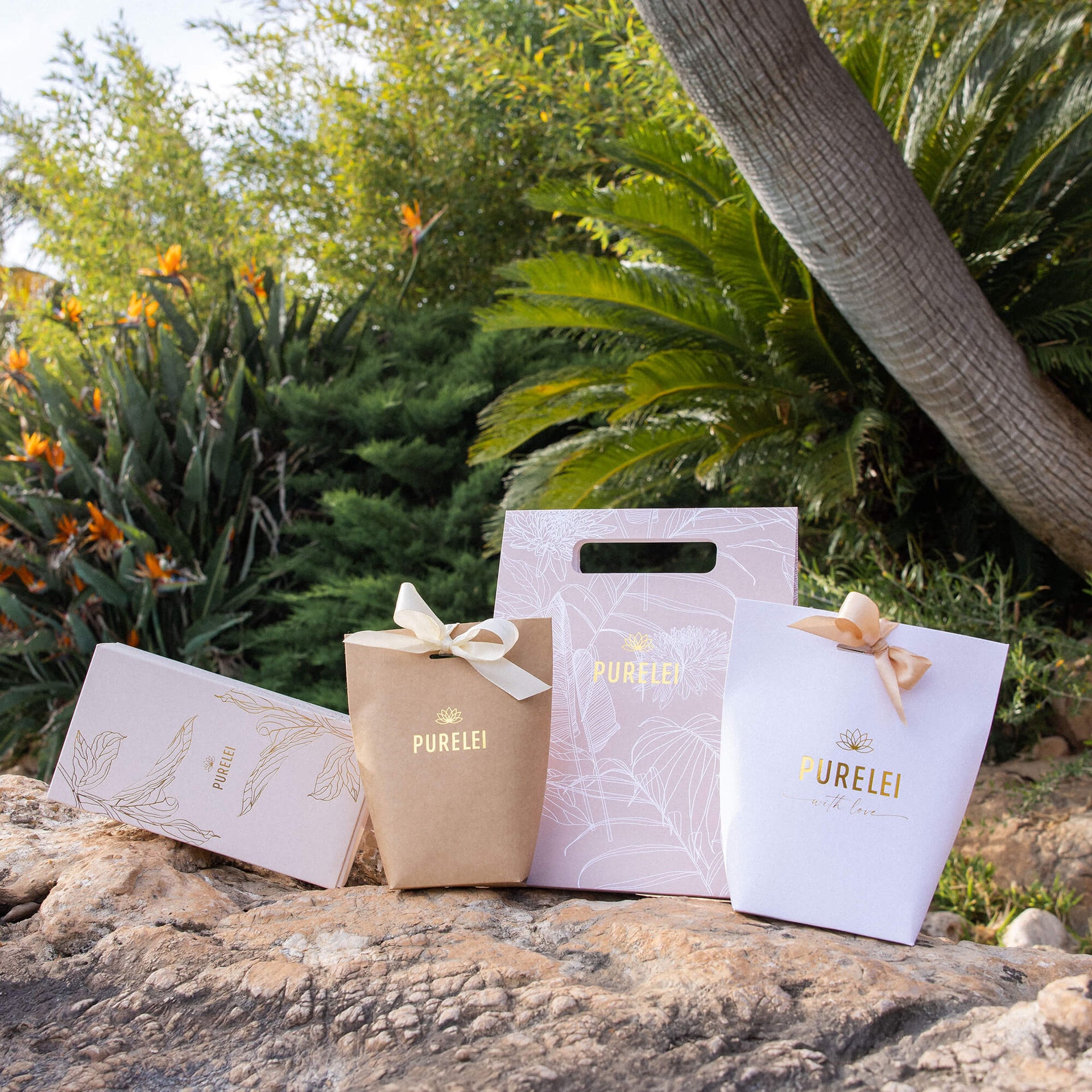 PURELEI Geschenkverpackung in Weiß und Gold mit filigranem Love-Design, elegant und feminin in Naturkulisse.