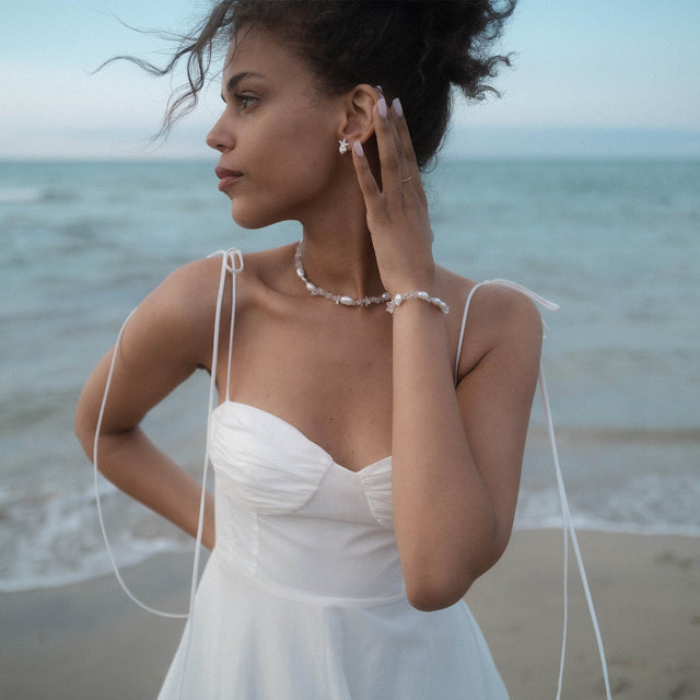 PURELEI Crystal Wave Kette mit Keshi-Perlen und Bergkristall, elegant am Strand getragen, feminin und natürlich.