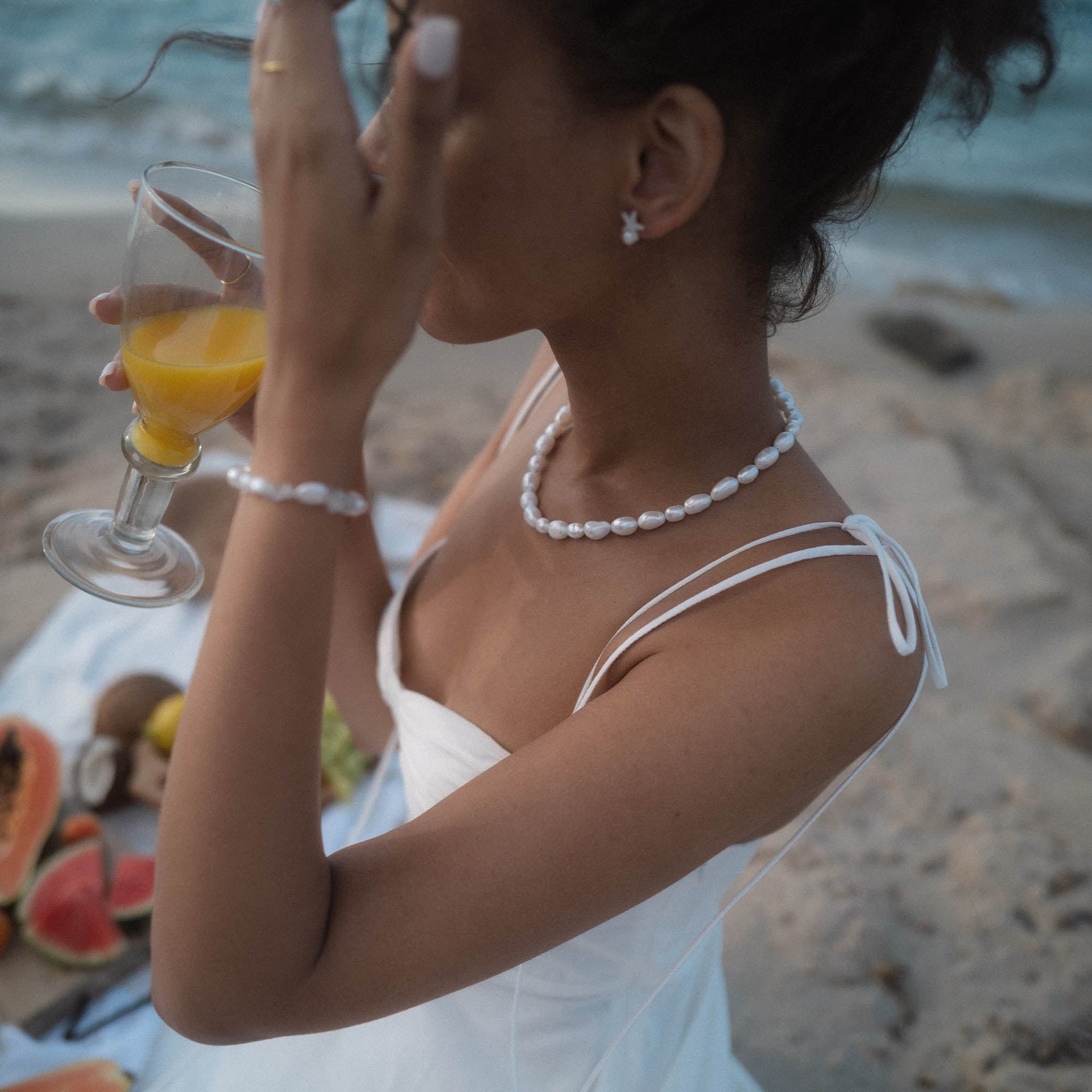 PURELEI Moonlight Keshi Kette aus goldvergoldetem Edelstahl mit weißen Keshiperlen am Strand getragen, elegant sommerlich