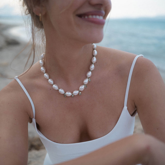 Perlenkette von PURELEI in strahlendem Weiß, elegant und feminin am Hals getragen.