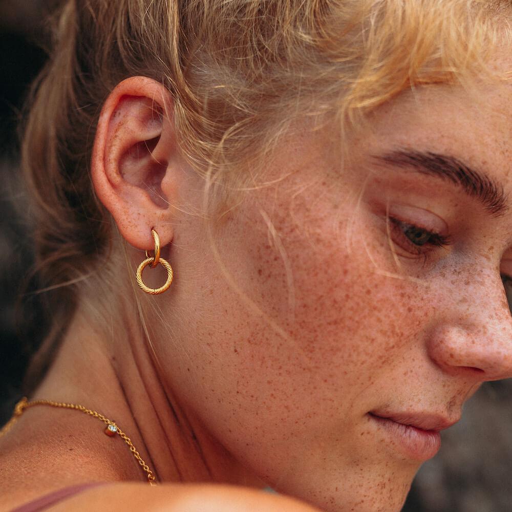 PURELEI Kii Elua Ohrringe aus 18K goldvergoldetem Edelstahl mit feiner Struktur, elegant und zeitlos getragen.