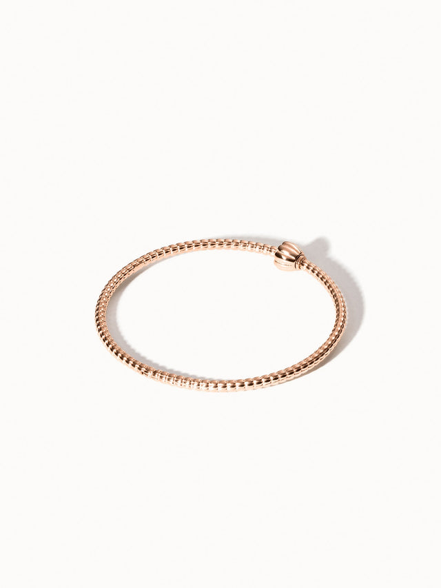 Lei Charm Armreif von PURELEI in Roségold mit filigraner Pikakeblütenstruktur, elegant und feminin präsentiert.