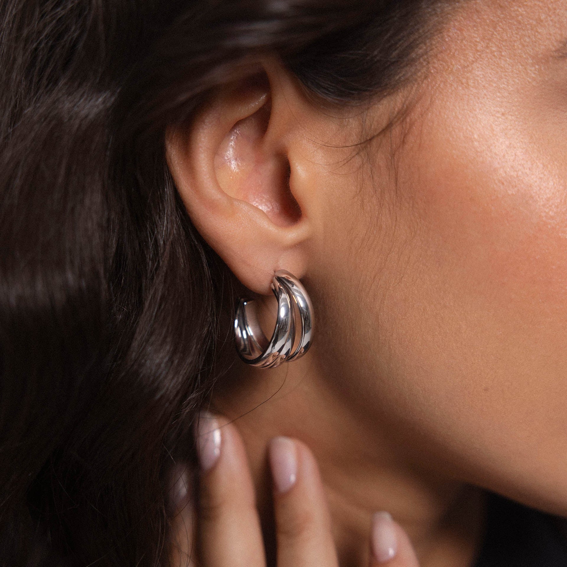 Roségoldene Creolen mit geschwungenem Design, getragen am Ohr, von PURELEI.