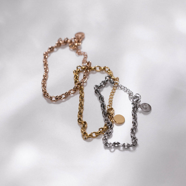 Drei PURELEI Dreamscape Armbänder in Roségold, Gold und Silber, nickelfrei, elegant und vielseitig im Sonnenlicht.