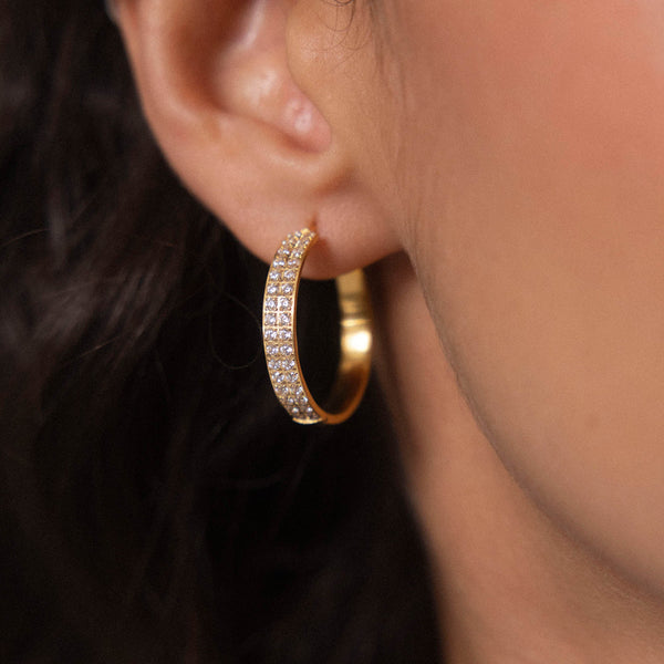 Roségoldene Creolen mit funkelnden Details, getragen am Ohr, von PURELEI.