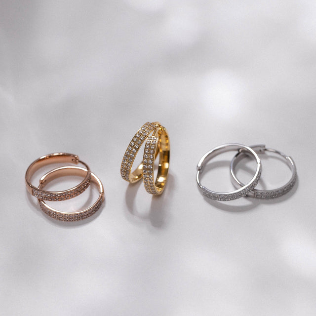 City Lights Ohrringe von PURELEI, vergoldete Creolen mit Zirkonia, elegant und feminin, glitzernd im sanften Licht.