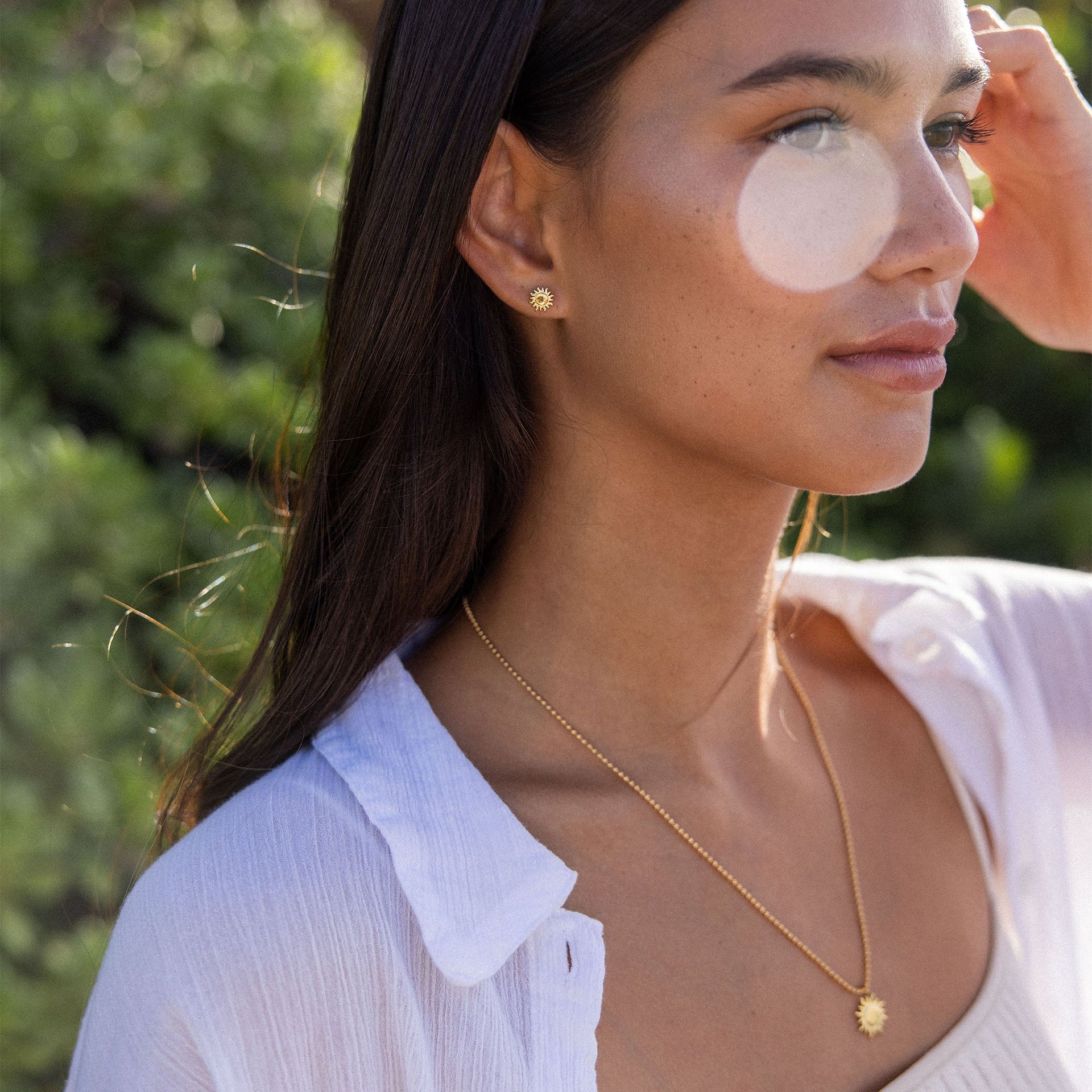 Roségoldene Kette mit Sonnenanhänger, getragen von einer Frau im Freien – PURELEI.