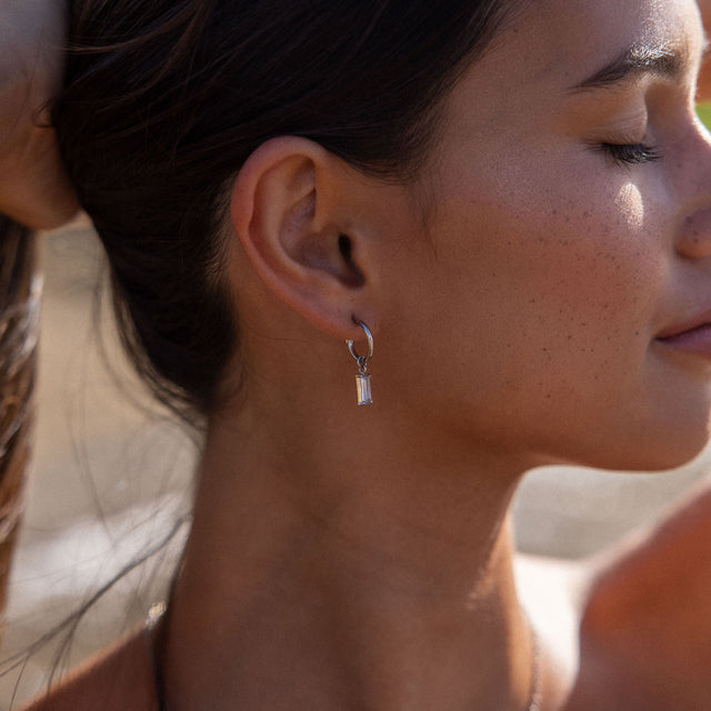 PURELEI Shine Bright Ohrringe in Silber mit funkelndem Zirkonia-Anhänger, elegant und feminin getragen.