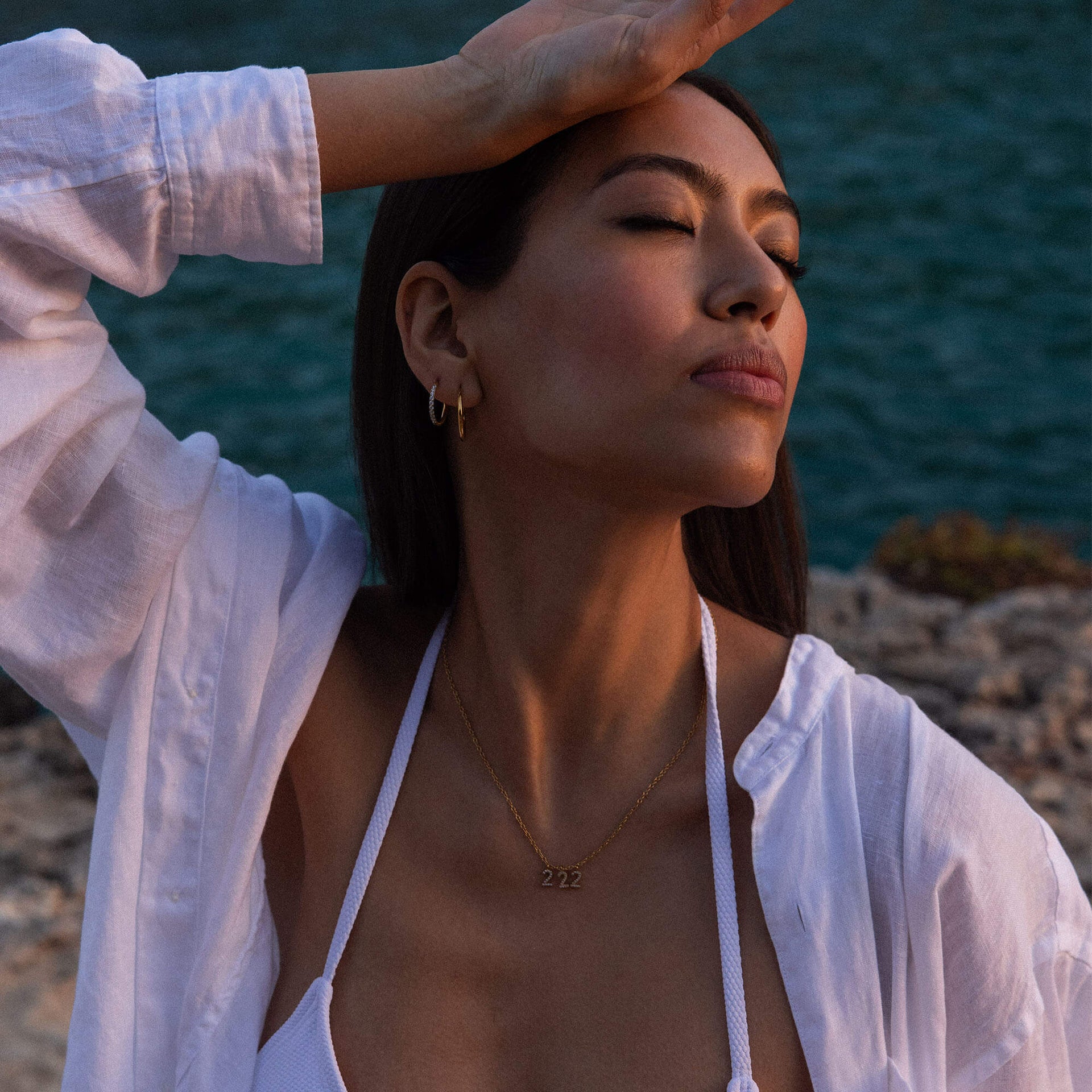 222 Kette aus 18K Gold mit Zirkonia-Anhängern im Ankerkettendesign, sanfte Abendstimmung.