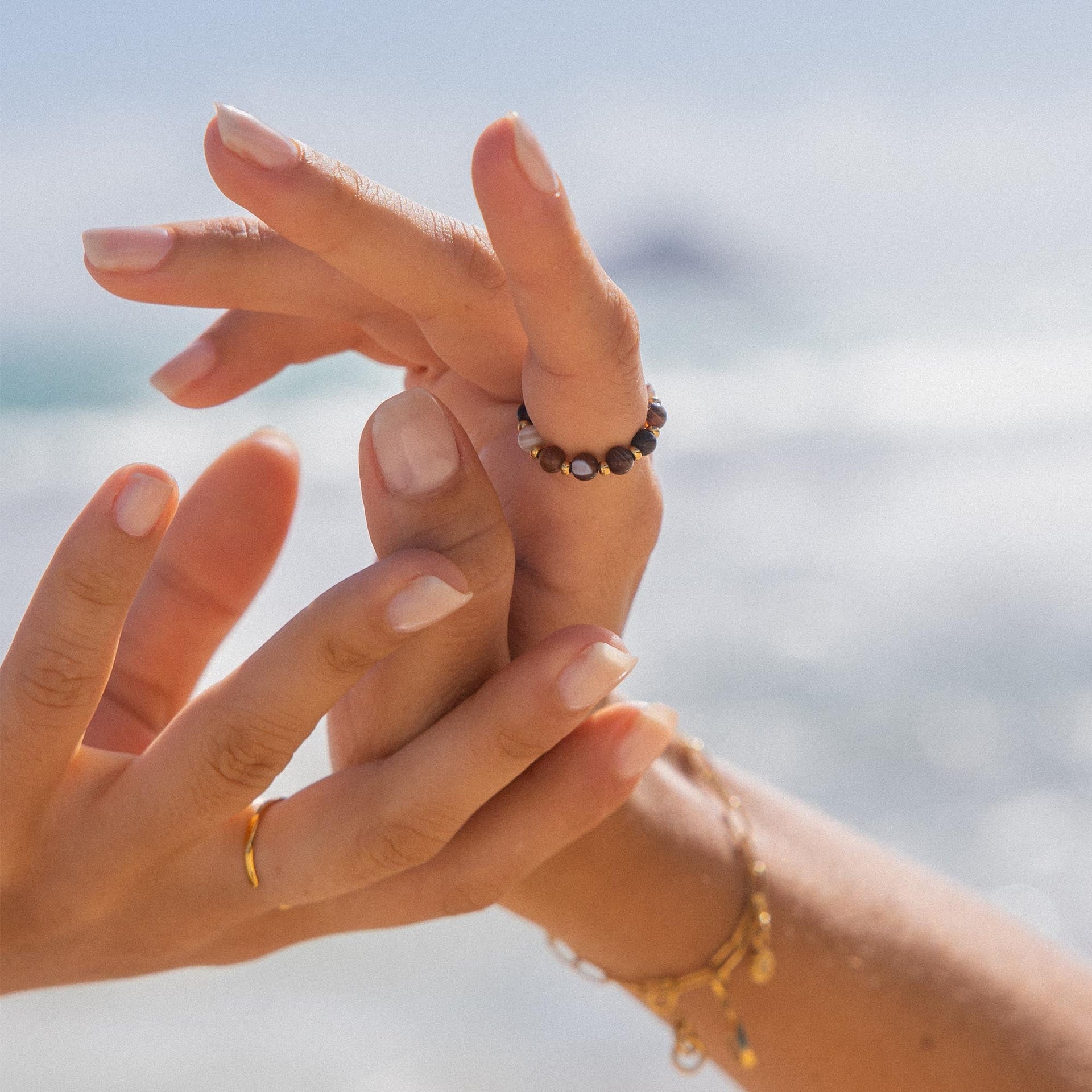 Anxiety Mahina Club Mokupuni Ring mit Naturstein- und Edelstahlperlen, getragen am sonnigen Strand, PURELEI Eleganz.