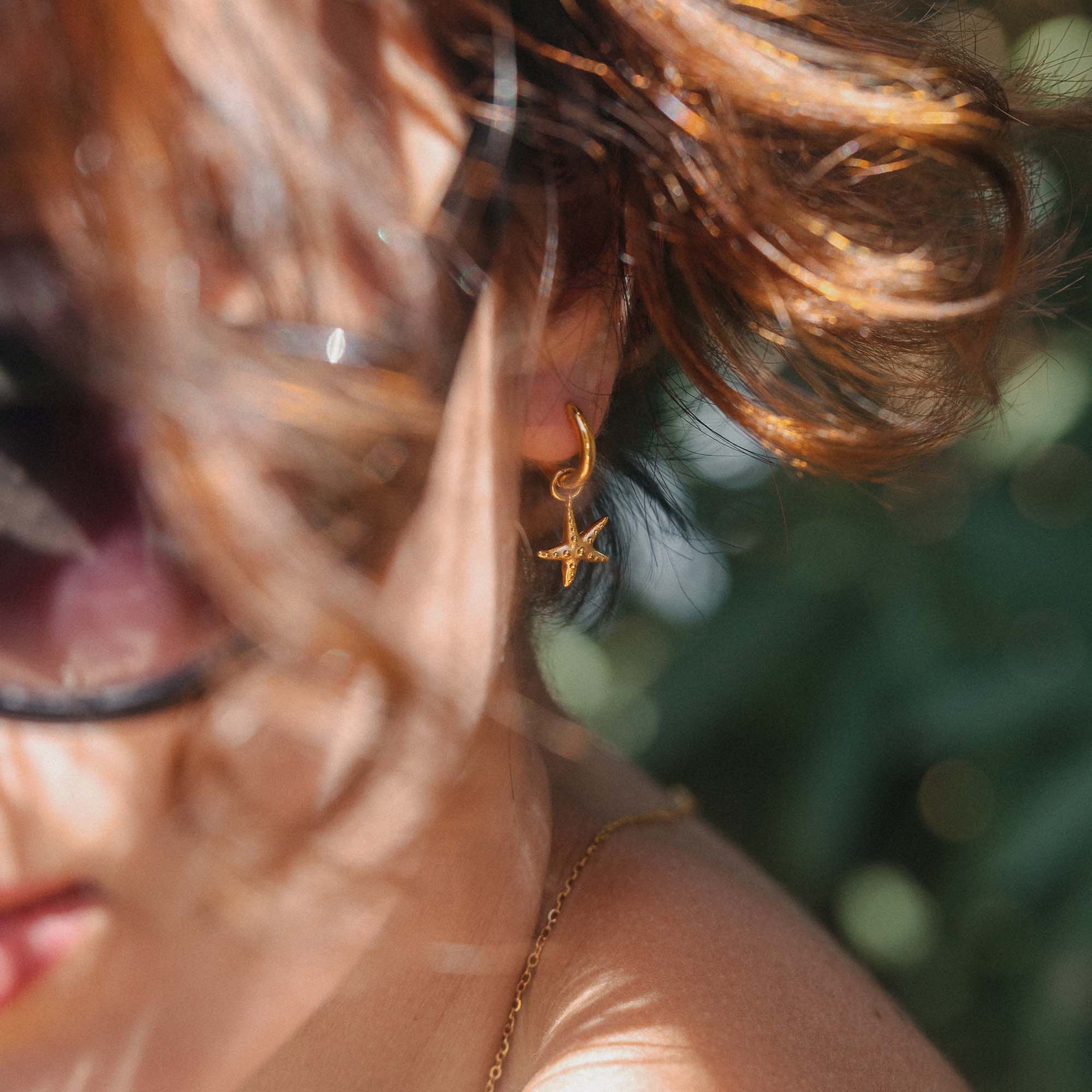 Roségoldene Sternenohrringe von PURELEI, elegant und maritim, umgeben von sanften Lichtspielen.