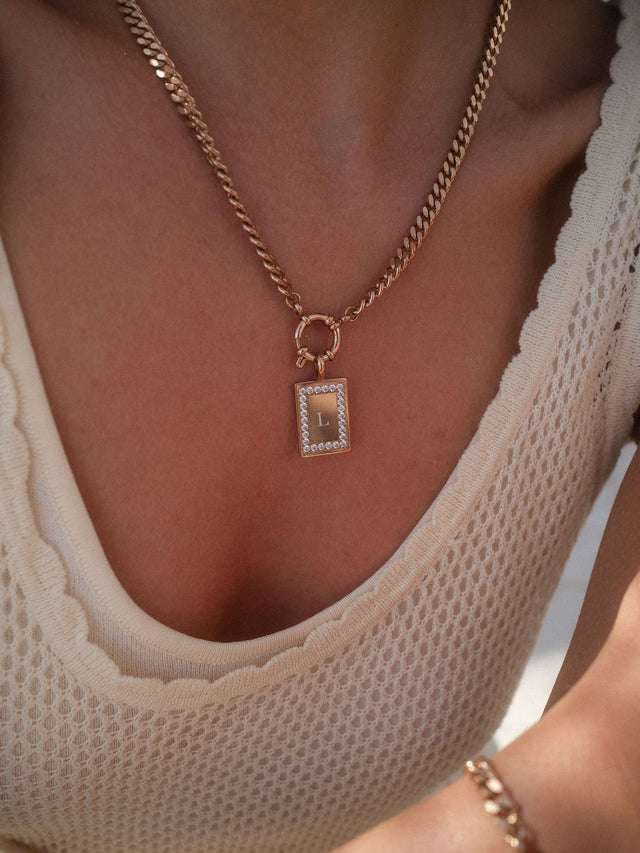 PURELEI Glimmer Charm aus 14K vergoldetem Edelstahl mit Zirkonia, elegant am Dekolleté getragen.