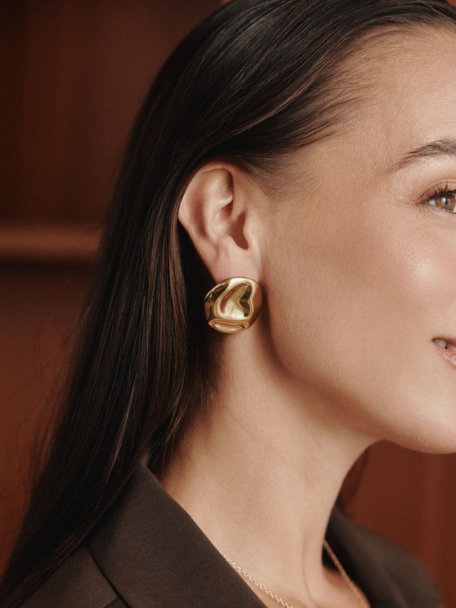 Elegante, roségoldene Ohrringe mit geschwungenem Design, getragen von einer Frau, PURELEI.
