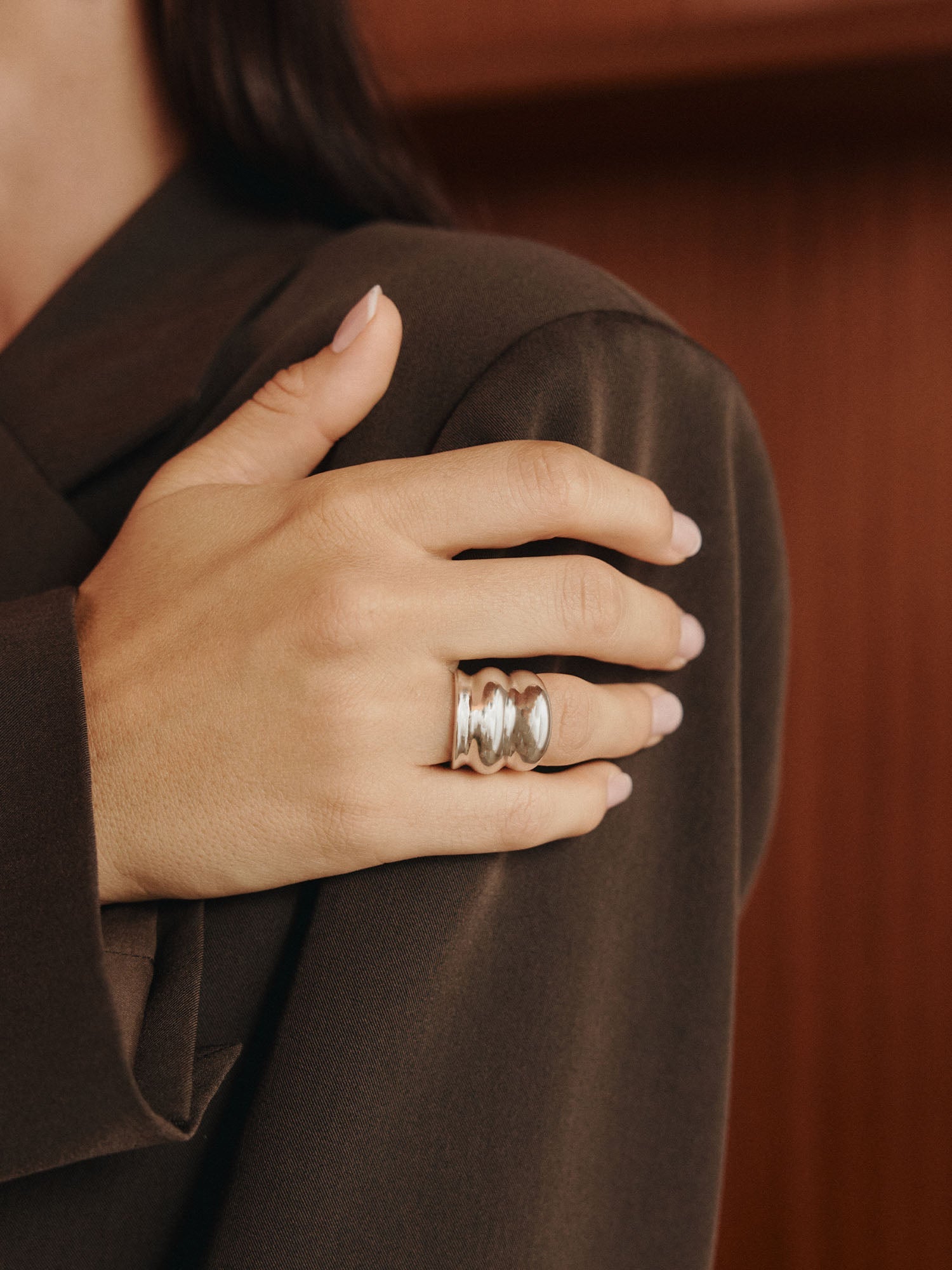 Roségoldener Ring mit geschwungenem Design, getragen an elegantem Outfit von PURELEI.