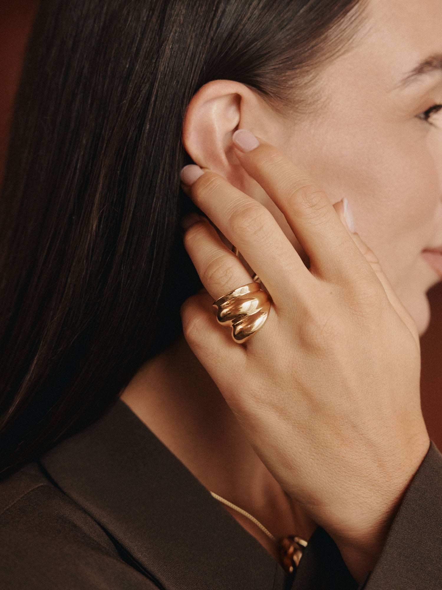 Goldener Ring mit geschwungenem Design, getragen von einer Frau, PURELEI. Elegante, feminine Ausstrahlung.