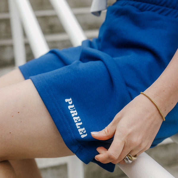 Dunkelblaue PURELEI Blue Paradise Shorts aus Baumwolle, lässig getragen, minimalistisch und sommerlich komfortabel.