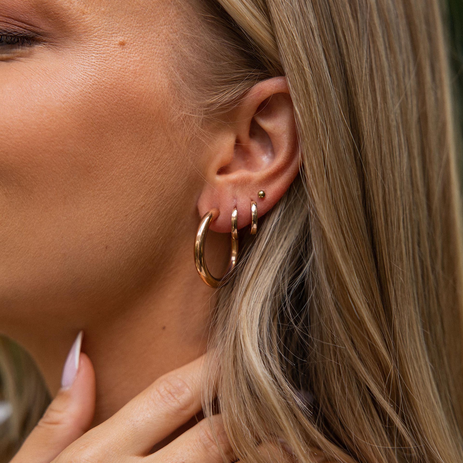 PURELEI Kumu O Creolen in warmem Gold, glatt und edel getragen, strahlen feminine Eleganz und Island-Spirit aus.