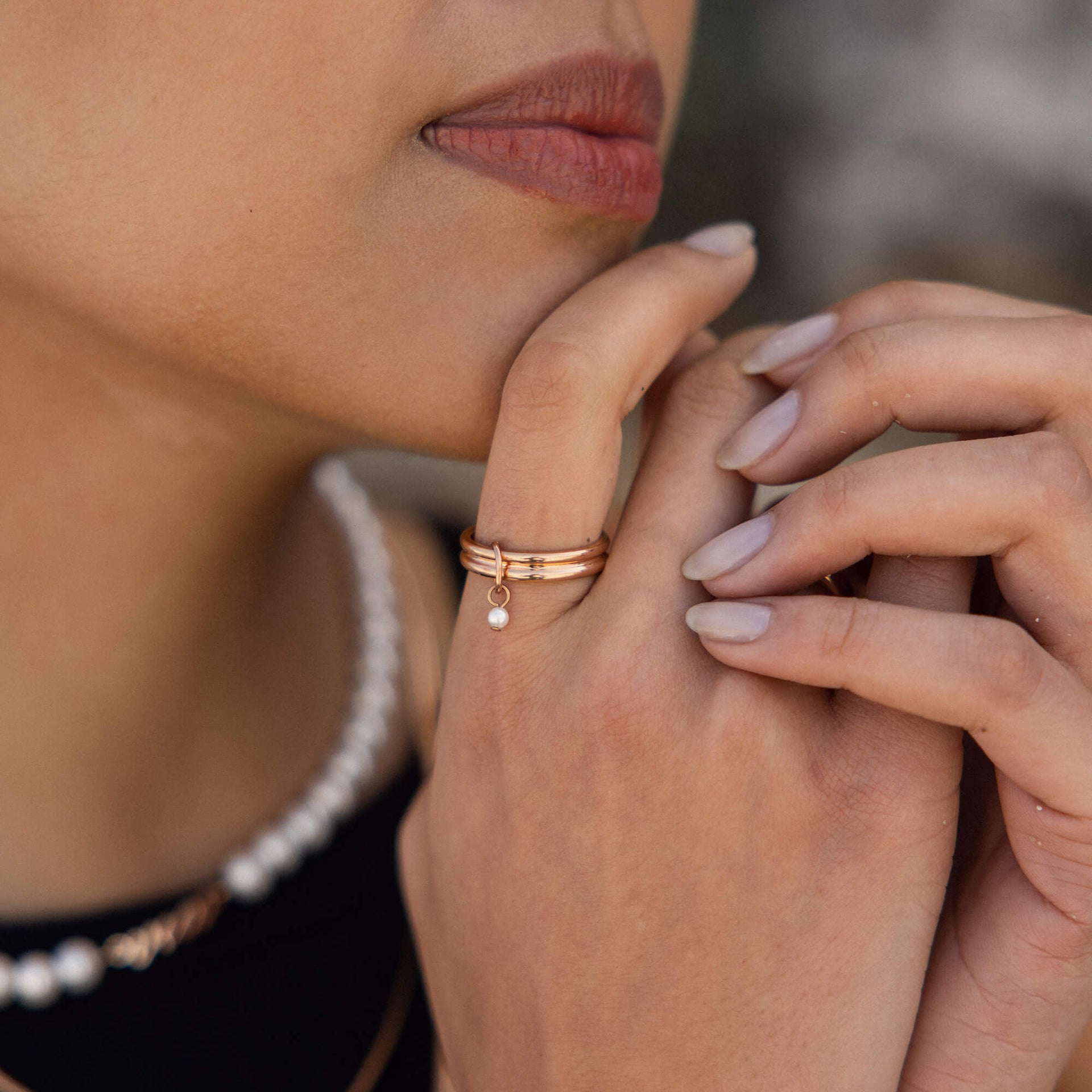 Roségoldene Ringe mit minimalistischen Designs, getragen von einer Hand, PURELEI.