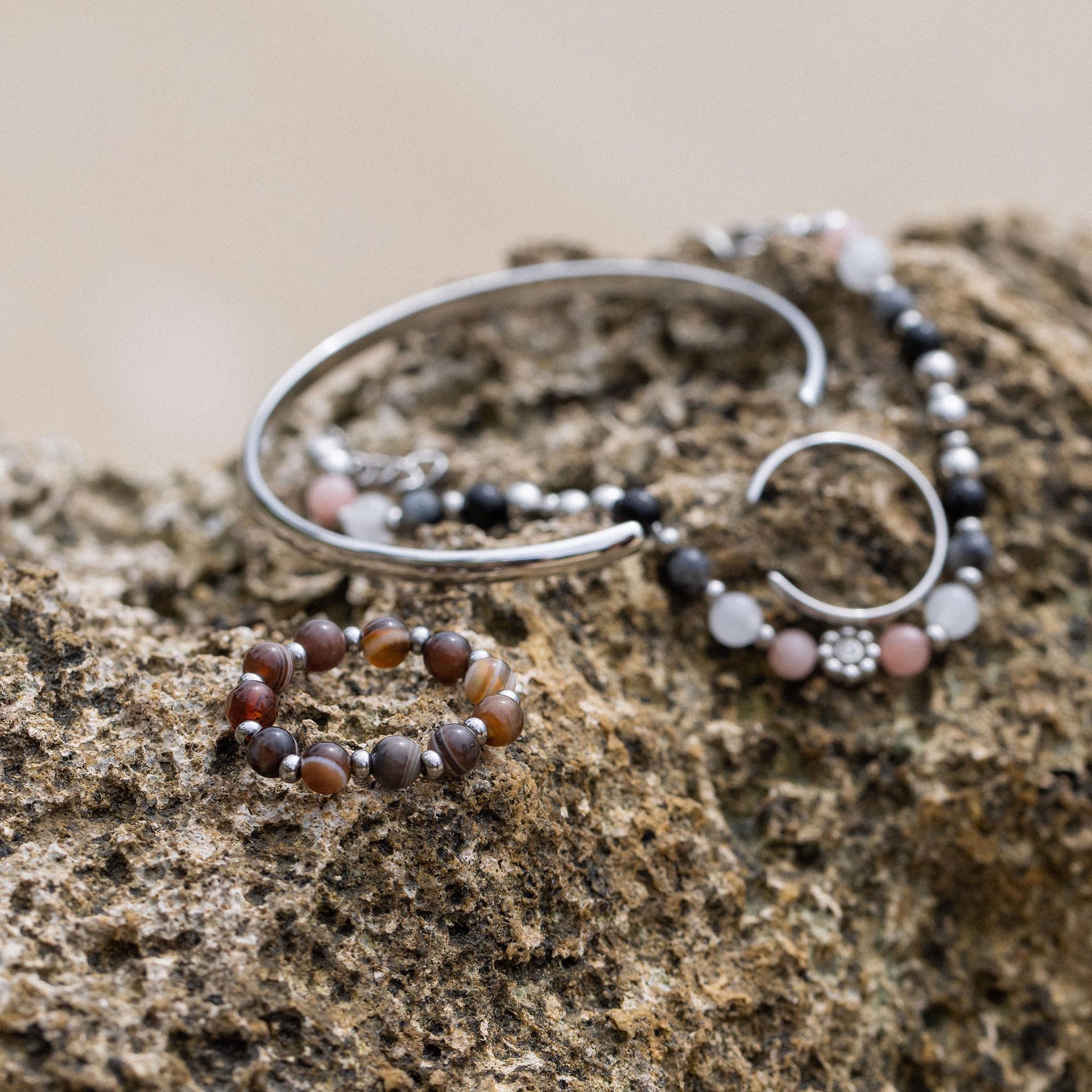 Anxiety Mahina Club Mokupuni Ring aus Edelstahl mit Natursteinperlen auf rauem Stein, PURELEI's feminine Eleganz.