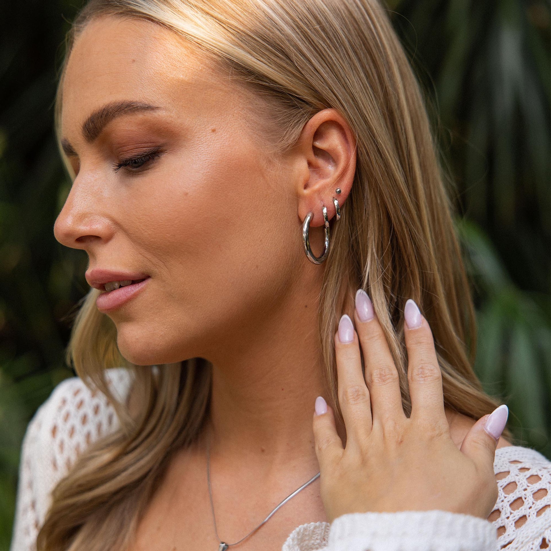 PURELEI Kumu O Creolen aus nickelfreiem, silberfarbenem Edelstahl getragen mit natürlichem, warmem Licht.