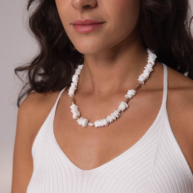 Wela Kette von PURELEI mit weißen Muschelstücken und Perlen, getragen, natürliche, feminine Strand-Ästhetik.