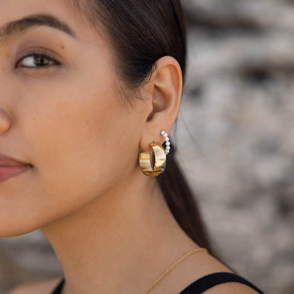 Roségoldene Creolen mit Perlen-Detail, getragen von einer Frau, PURELEI inspiriert.