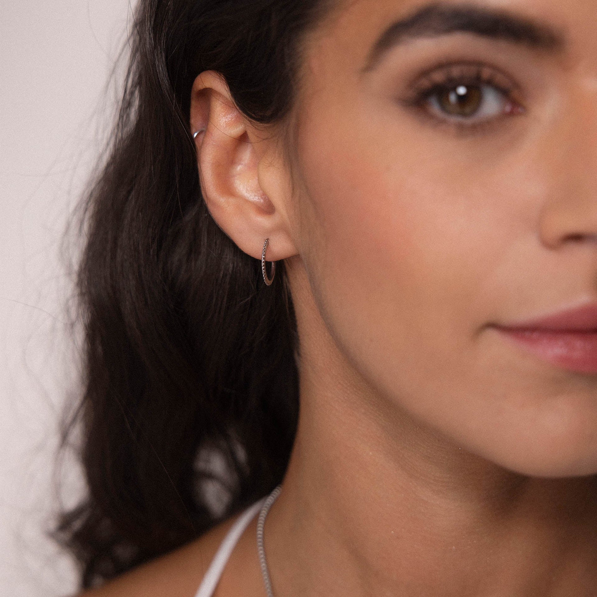 Silberne, nickelfreie Olani Creolen am Ohr, zart und elegant, verkörpern PURELEIs zeitlose Leichtigkeit.