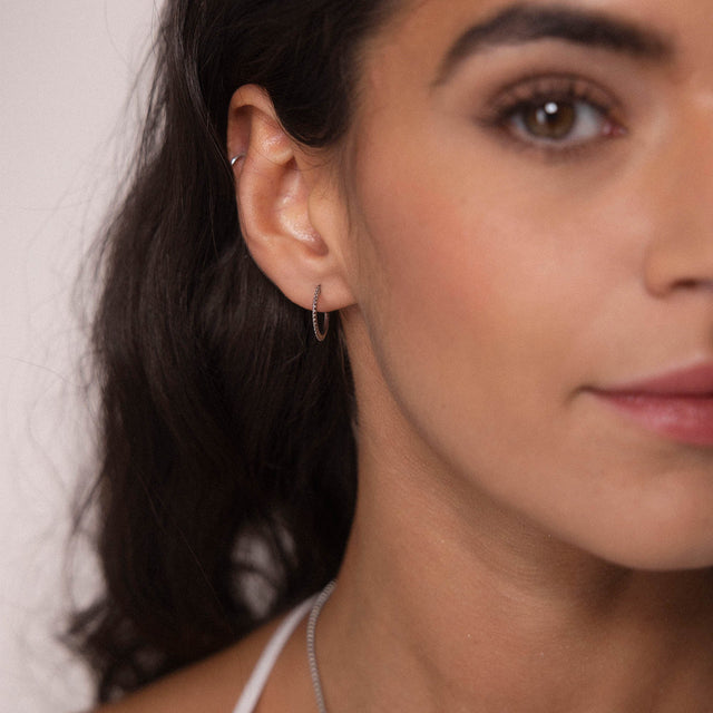 Silberne, nickelfreie Olani Creolen am Ohr, zart und elegant, verkörpern PURELEIs zeitlose Leichtigkeit.