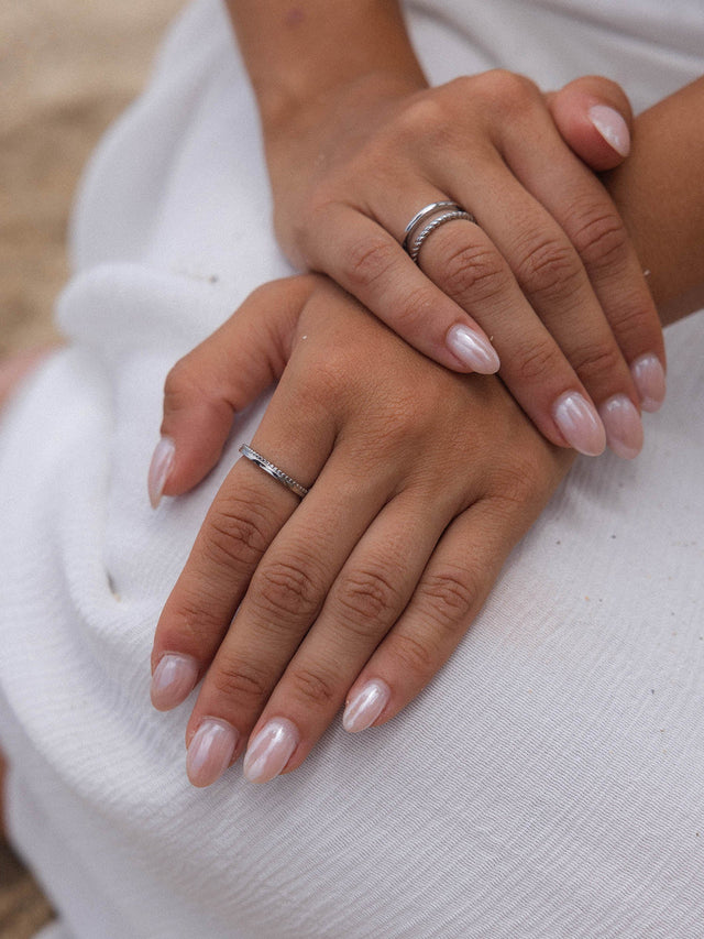 Silberne Ringe von PURELEI auf zarten Händen mit schimmernden Nägeln, elegant und feminin.