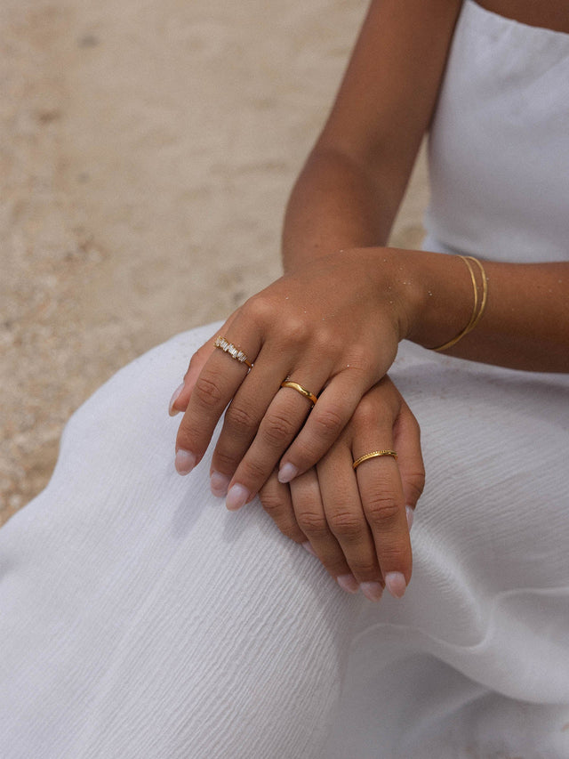 Zarte Ringe aus Roségold und Silber, getragen auf einer weißen Decke – PURELEI Eleganz.