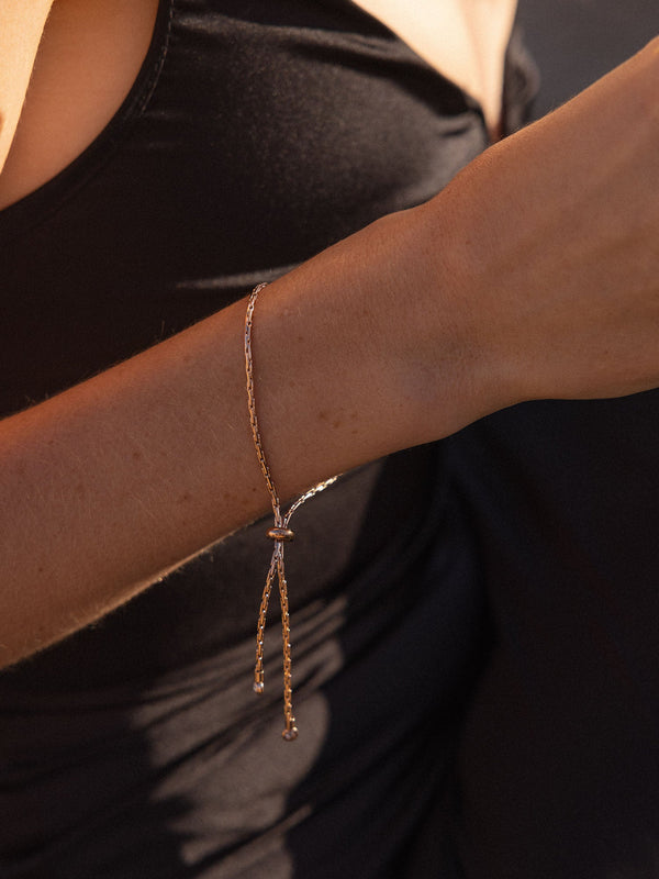 Zartes, roségoldenes Armband mit Knoten-Design, getragen auf einem Handgelenk, PURELEI.