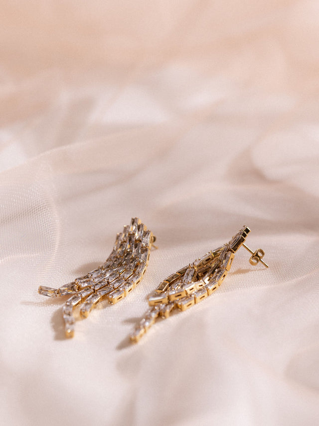 Roségoldene Ohrringe mit filigranem Design auf zartem Stoff, PURELEI.