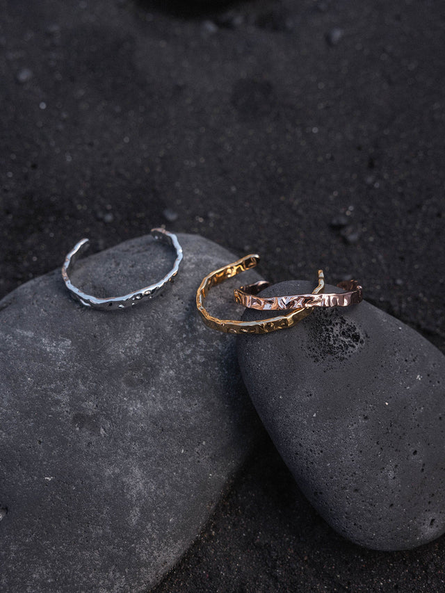 Volcano Armreif von PURELEI in Gold, Silber und Roségold mit gehämmerter, unregelmäßiger Oberfläche auf Lavastein.