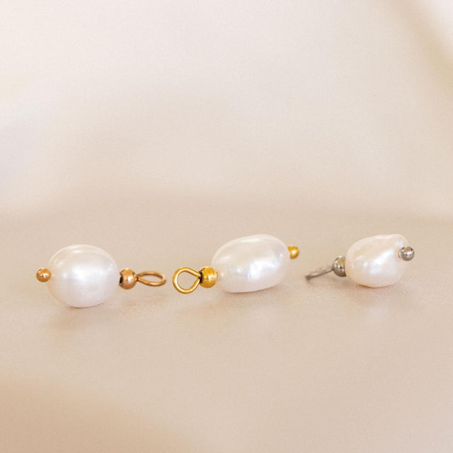 Schimmernder Keshi Perlen Charm in Gold, Silber und Roségold, edel inszeniert auf sanftem beigem Hintergrund – PURELEI.