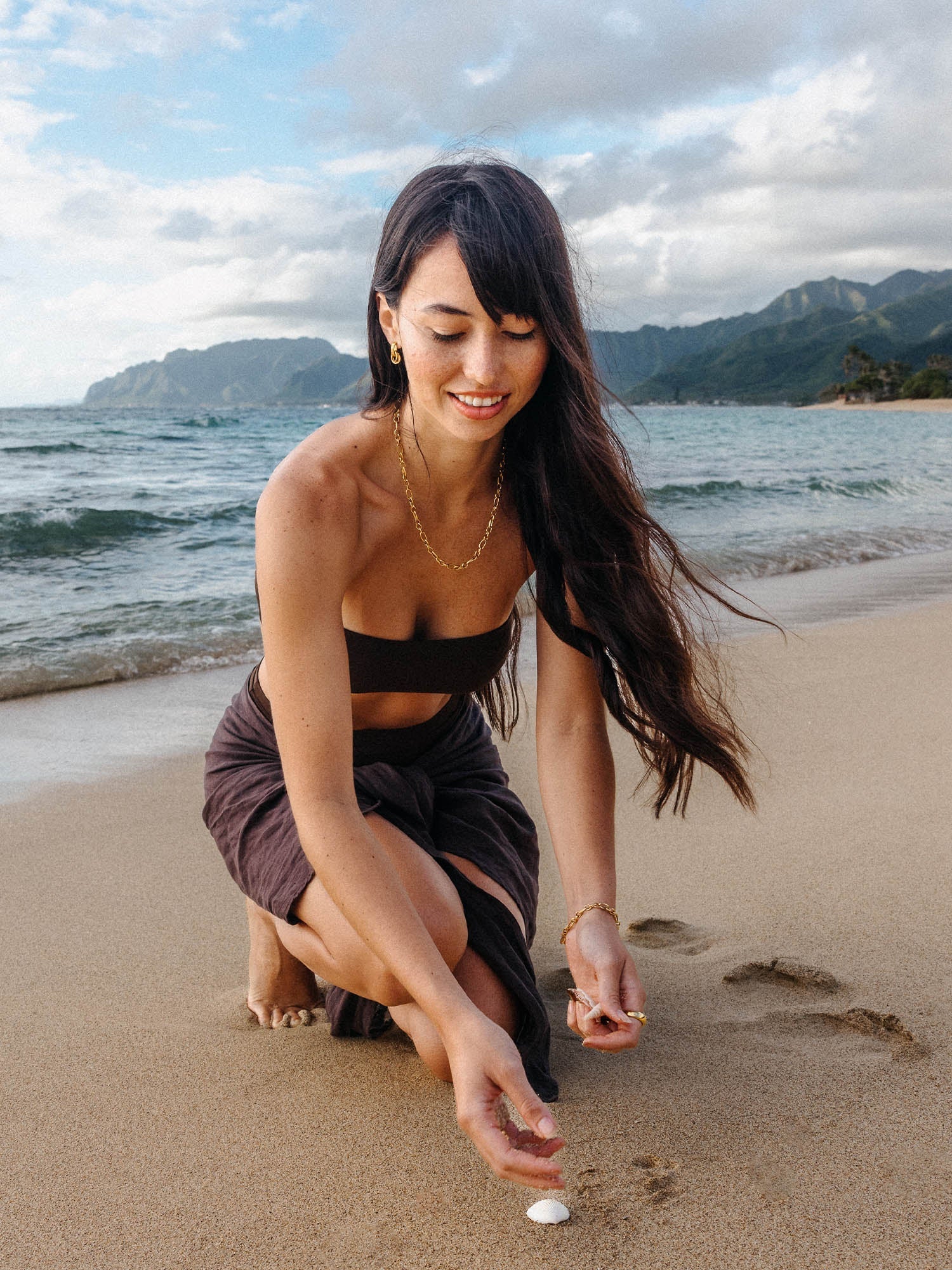 PURELEI He Nui Ohrringe aus 18K Gold verschlungene Ringe, getragen am Strand, elegant und selbstbewusst.