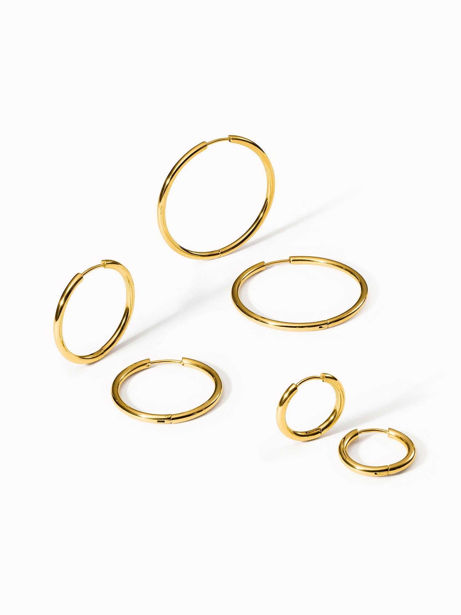 Goldene Creolen in verschiedenen Größen, PURELEI, elegant und modern.