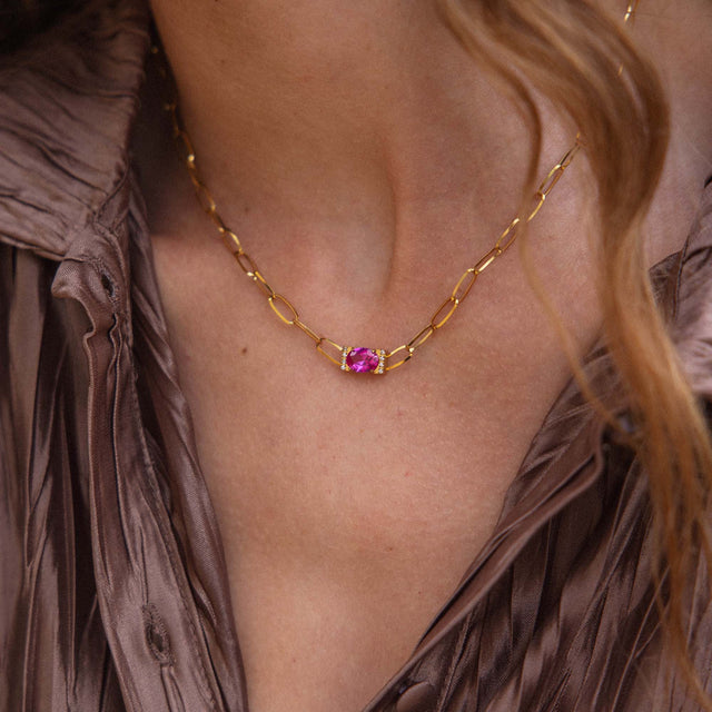 Goldene Kette mit einzigartigem Anhänger, getragen auf einer eleganten Bluse von PURELEI.